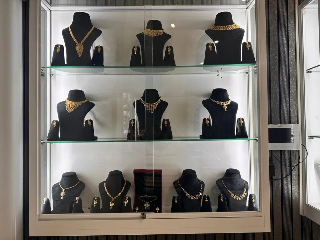 In-store display case featuring Delhi Jewellers' gold necklace collection